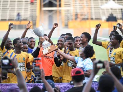 
Clarendon College goalkeeper and captain, Lydel Rodney, lifts the Ben Francis Cup title while his teammates celebrate after a 2-1 win over Cornwall College at the National Stadium yesterday.