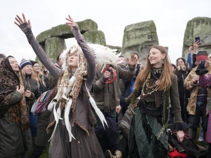 People take part in the winter solstice celebrations during sunrise at the Stonehenge prehistoric monument on Salisbury Plain in Wiltshire, England.