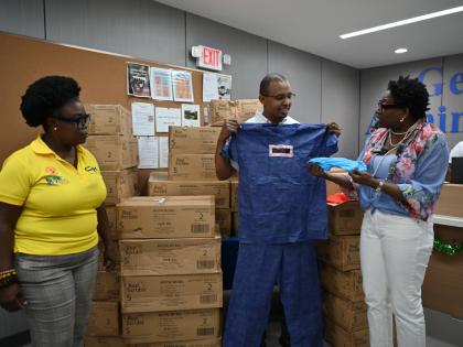 Janet Silvera (right), the chairman of the Sarah’s Children charity, presents a donation of 1,440 medical scrubs to Dr Dwayne Hall (centre), head of surgery at the Cornwall Regional Hospital (CRH) in St James, and Cassandra Laing, CRH’s operations mana