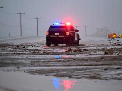 A California Highway Patrol officer drives along California State Route 138 through mud Wednesday, December 24, 2025, near Wrightwood, California. (AP Photo/Wally Skalij)