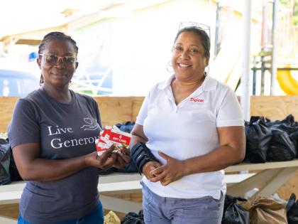 Digicel Foundation CEO Charmaine Daniels (right) hands over $300,000 worth of hardware vouchers to Sadie Brisstell, administrative assistant at West Haven Children’s Home, during a visit to the facility in Hanover. 