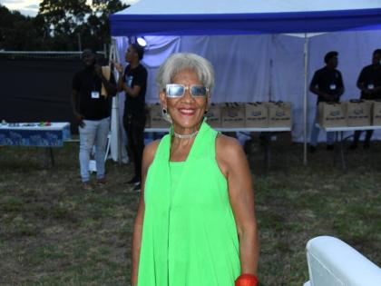 Dressed in lime green, Dr Sherrill Chong, community transformation specialist, brings festive spirit at the An Evening of Light, Music and Giving benefit concert.