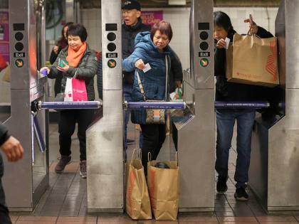Shoppers swipe their MetroCards as they enter the subway turnstiles, in November 2024, in New York. 