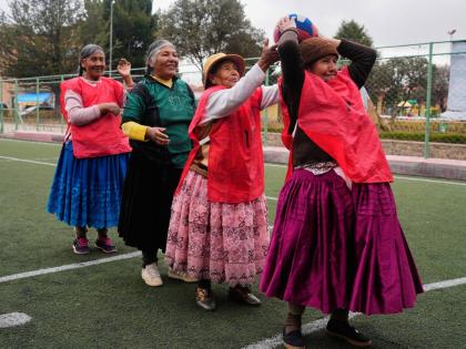 An Aymara grandmother passes the ball during a warm up before the start of a handball match in El Alto, Bolivia.