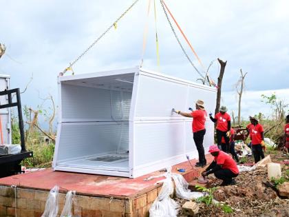 Volunteers install a container house for mother of six, Ashella Baker, in Middle Quarters, St Elizabeth recently.