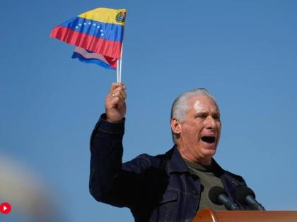 Cuban President Miguel Diaz-Canel waves Venezuelan and Cuban national flags during a rally in Havana, Saturday, January 3, 2026, in solidarity after the US captured President Nicolas Maduro and flew him out of Venezuela. (AP Photo/Ramon Espinosa)