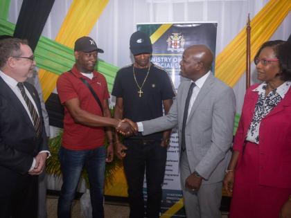 Minister of Labour and Social Security, Pearnel Charles Jr. (second right), greets farm worker, André Ellis, during a send-off ceremony for seasonal agricultural workers to Canada, held at the Ministry’s Overseas Employment Centre on East Street in down