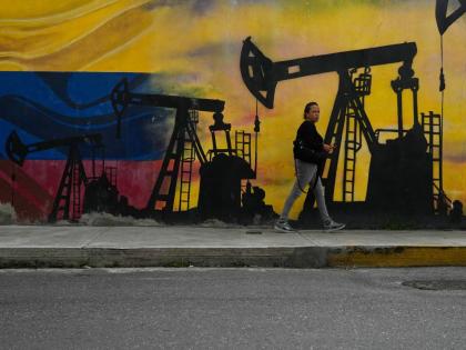 A local walks past a mural featuring oil pumps and wells in Caracas, Venezuela on January  6, 2026. 