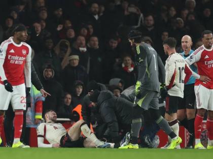 Trainers check on Liverpool’s Conor Bradley (second left)  during the English Premier League match between Arsenal and Liverpool in London, yesterday.