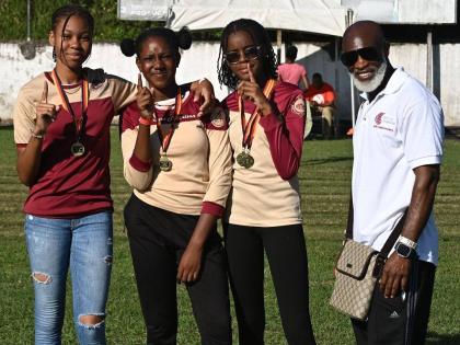Comets Club International President Michael Campbell (right) poses with members of the Herbert Morrison Technical High School team after presenting them with medals at the second staging of the Run for the Republic development meet at the school on Saturda