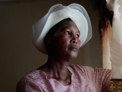 Anne Bonareri, a widow, looks out the window of her home in Kisii, Kenya.