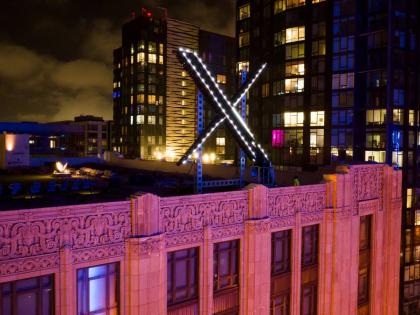 Workers install lighting on an ‘X’ sign atop the company headquarters, formerly known as Twitter, in downtown San Francisco, July 28, 2023.