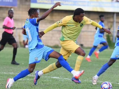 Treasure Beach FC’s Karim Bryan (right) evades a tackle from Molynes United’s Rashawn Livingston during their Jamaica Premier League football match at Drewsland yesterday. Treasure Beach FC’s Karim Bryan (right) evades a tackle from Molynes United’