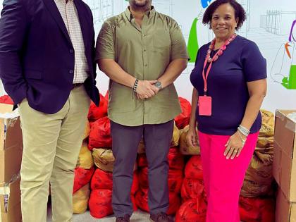Corah Ann Robertson-Sylvester, president, SAJ, and Terrence Brooks, GM, SAJ, receive care packages from Carlos A. Murillo C., GM, ZIM–Carib Star (centre).