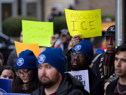 People raise signs in support of immigrants during a news conference outside Greater New York Federal Building, Tuesday, January 13, 2026, in New York. (AP Photo/Yuki Iwamura)