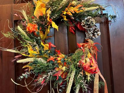 Christmas wreath by Boho Botanics, crafted with fragrant local evergreens, sun‑dried millet, preserved oak and eucalyptus, and finished with pine cone accents.