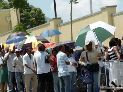 In this file photo visa applicants are seen waiting outside the US Embassy in Kingston.