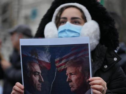 A protester holds up a poster showing Iran’s exiled crown prince Reza Pahlavi, (left) and US President Donald Trump, as she demonstrates outside the House of Parliament, in London.