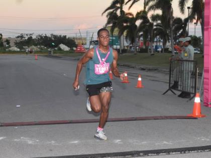 Defending Champion, male, Brandon Kerr crosses the finish line in 17:33, winning the Kiwanis Club of Providence-Montego Bay Breast Cancer 5K Run, Walk and Wheelchair for the second year on Sunday at the Fairview Office Complex.