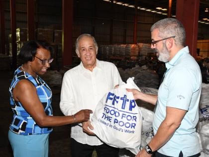 Paulette Simpson (left), executive, corporate affairs and public policy for the JN Group in the UK examines items shipped to Food for the Poor along with Chief Operating Officer of Food for the Poor, Mark Khouri (right) and Chairman of the JN Foundation, P