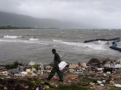 A man walks along the coastline during the passing of Hurricane Melissa in Kingston.