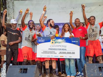 Members of Friends for Real, an Olympic Gardens-based football team celebrate winning the Pocket Rocket Foundation’s Six-A-Side Peace Through Sports Football Competition in 2024. Sharing in the moment is founder and Chairman of the foundation, Shelly-Ann