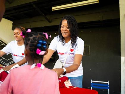 Celia Ebanks (right) and Gabriel Hall of the JMMB Joan Duncan Foundation distribute gift packages to children during this year’s children’s treat held at the Philip Sherlock Centre for the Creative Arts, UWI, Mona. This year, the Foundation hosted 158 