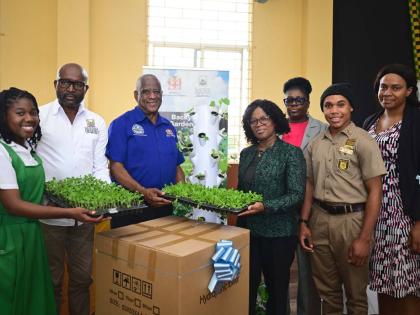Minister of State in the Ministry of Agriculture, Fisheries and Mining, Franklyn Witter (third left), presents a vertical hydroponic tower to Vice-Principal of Manchester High School, Hillary Morgan (fourth left), during a ceremony held at the school on Ja