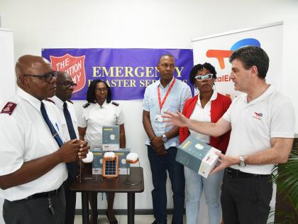 Vincent Daniault (right), managing director, TotalEnergies Jamaica, presents solar-powered lights to Colonel Edwards Lyons (left), chief secretary in charge of Caribbean territories emergency disaster services, Salvation Army, to assist in their hurricane 