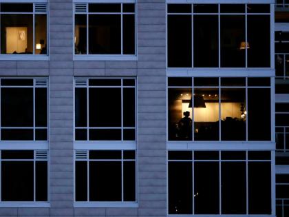 A person looks out of a window in an apartment building in Kansas City, Missouri.