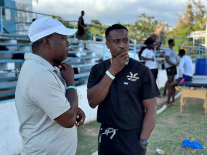 
St George’s College track and field team head coach, Gavin James (right), and assistant coach Kevin Pryce have a discussion at the Emmet Park Pavilion recently.