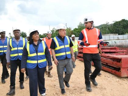 Minister of Water, Environment and Climate Change, Matthew Samuda (centre), along with Member of Parliament for St Catherine North Central, Natalie Neita-Garvey (left), and Project Manager with Vinci Construction, Thomas Savary (right), tour the Rio Cobre 