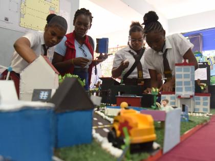 Students from Holmwood Technical High School organise their exhibit just before the start of the STEAM in Action Expo, which was held at the Chinese Benevolent Association in St Andrew last Thursday.