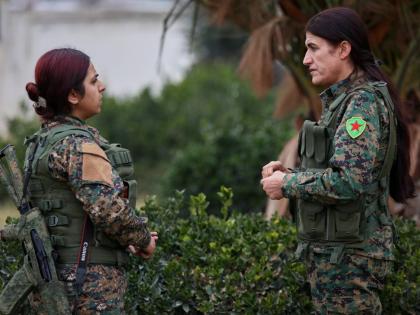 Rohlat Afrin, commander of the Syrian Democratic Forces (SDF) Women’s Protection Units, right, talks with a soldier in Qamishli, Syria.