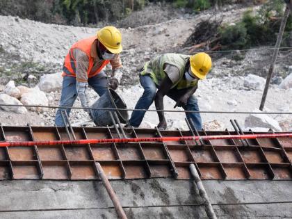 An employee of China Harbour Engineering Company Ltd (CHEC) constructs a retaining wall along the St Thomas main road in the vicinity of the Grants Pen community in 2020.