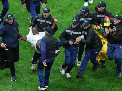 Senegal supporters are taken from the stadium by security officers after a controversial penalty was awarded to Morocco late on during the Africa Cup of Nations final footbal match in Rabat, Morocco on January 18.