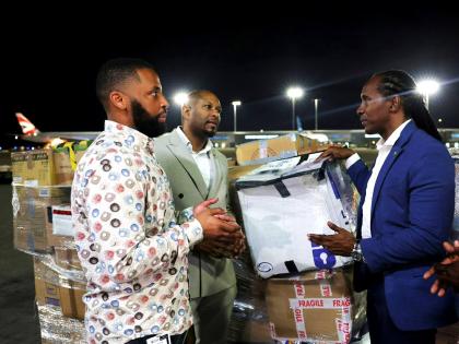 Alando Terrelonge (right), State Minister in the Ministry of Foreign Affairs and Foreign Trade, receives one of the packages from Nathaniel Peat (centre), GJDC UK Rep, and Jackson Smith, CEO of Fantasy Wings, both of whom organised the diaspora-led relief 