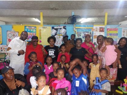 CEO of JAMCO Entertainment Michael Small (back row left) poses for a photograph with staff and students at the Mount Olivet Basic School in St James.
