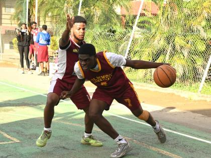 Holmwood Technical High School’s Nickoy Knight (right) tries to dribbles by Herbert Morrison Technical High School’s Joshua Ferguson during their ISSA Schoolboy Under-19 Basketball quarterfinal match at Herbert Morrison court yesterday.