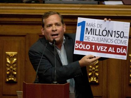  Opposition lawmaker Juan Pablo Guanipa displays a sign that reads in Spanish "More than a million residents of Zulia State eat only once a day" during an intervention against Venezuela's President Nicolas Maduro at National Assembly, in Caracas, Venezuela