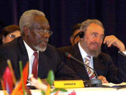 Prime Minister P.J. Patterson (left) addresses a press conference following the 2nd CARICOM/Cuba Summit in Barbados on December 8, 2005.  Listening at right is Cuban President Fidel Castro.
