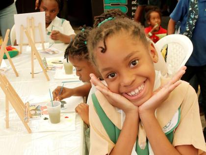 Adelyn Mothersill was all smiles as she painted a portrait of the late Bob Marley at his 81st birthday celebration on Friday at the Bob Marley Museum