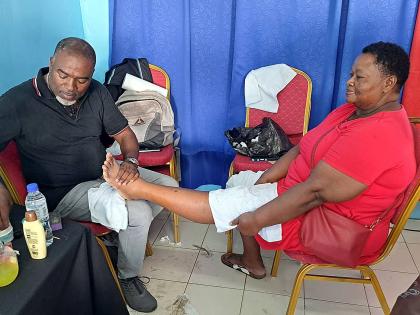 Waterford Councillor Dr Fenley Douglas assists Waterford senior Veroni Christian during the care initiative.