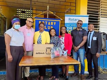 Rotary Club of New Kingston District Governor William Aiken (second from left) and president Alex Robinson (far right), joined by Vice‑Principal of Constant Spring Primary and Infant School Michelle Wiggins (fifth from left), during the handover of an AE
