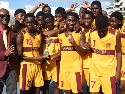 Wolmer’s Boys’ School coach, Howard Harvey (left), celebrates with his charges after winning the ISSA Under-16 Urban Schoolboy Basketball title at St George’s College yesterday.