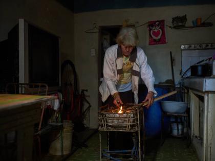Minorkys Hoyos Ruiz lights coals to cook dinner during a scheduled blackout to ration energy in Santa Cruz del Norte, home to one of Cuba’s largest thermoelectric plants, late afternoon Tuesday, Feb. 3, 2026. 