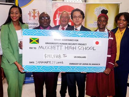 Minister of State in the Ministry of Education, Skills, Youth and Information, Rhoda Moy Crawford (left), joins Principal of Muschette High School in Trelawny, Leighton Johnson (second left), as he receives a cheque valued US$151,588 from Japan’s Ambassa