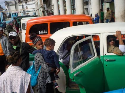 People wait their turns to board shared taxis in Havana, Cuba.