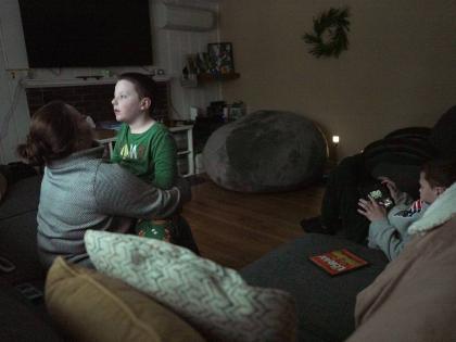 Ronan Murphy snuggles with his mom, Andrea, while looking at the snow falling outside his home while brother, Connor sits nearby in Ayer, Massachusetts, USA, on January 17, 2026. 
