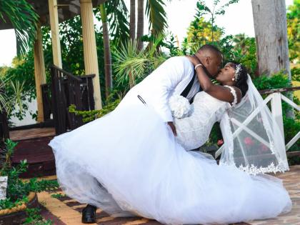 Glenroy sweeps his bride into a dip, sharing an enchanting kiss.